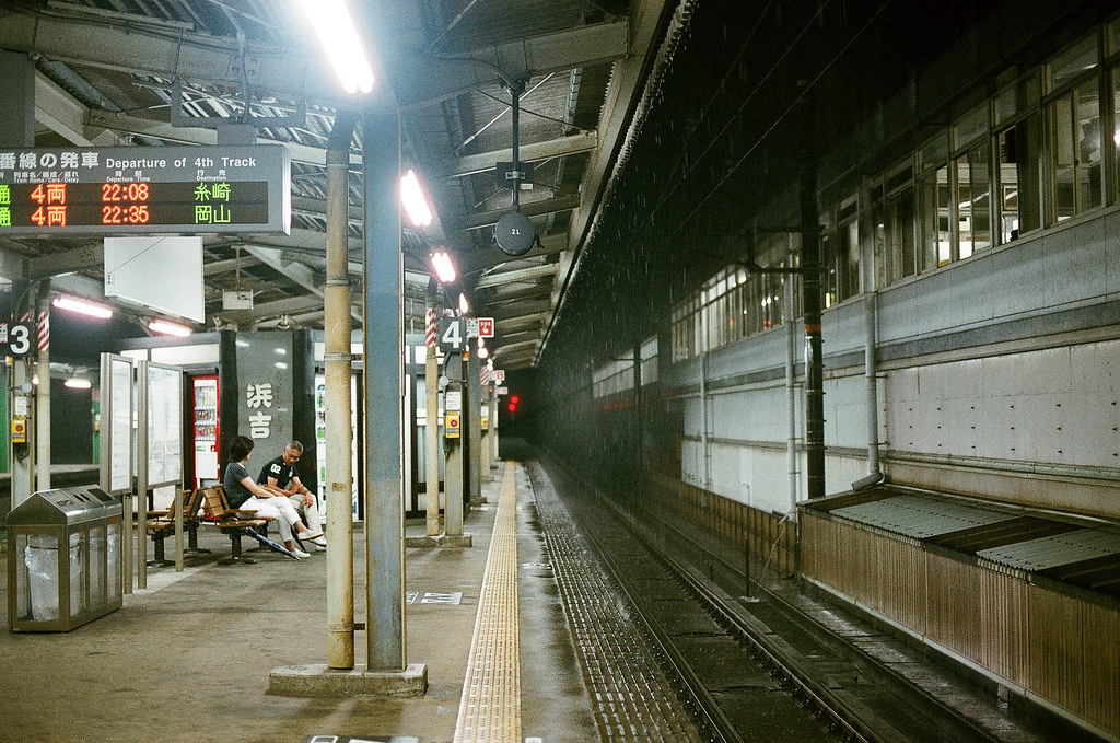 三原駅 みはら - Mihara, Hiroshima 2015/08/29 一直不斷的下雨，右邊上面是新幹線的月台，一段時間就會聽到新幹線列車呼嘯而過！那時候看著下雨還是有點小小悲傷，我又跑來一個好遠的地方，但是事情還是這樣的存在 ...  抵達廣島機場後，搭公車前往三原市等火車到尾道，如果公車開快五分鐘，我就可以趕上晚上九點五十三分的火車，可是日本的公車很準時，表定九點五十五分到就一定遵守，所以只好在三原駅月台等末班車。  Nikon FM2 / 50mm FUJI X-TRA ISO400 Photo by Toomore