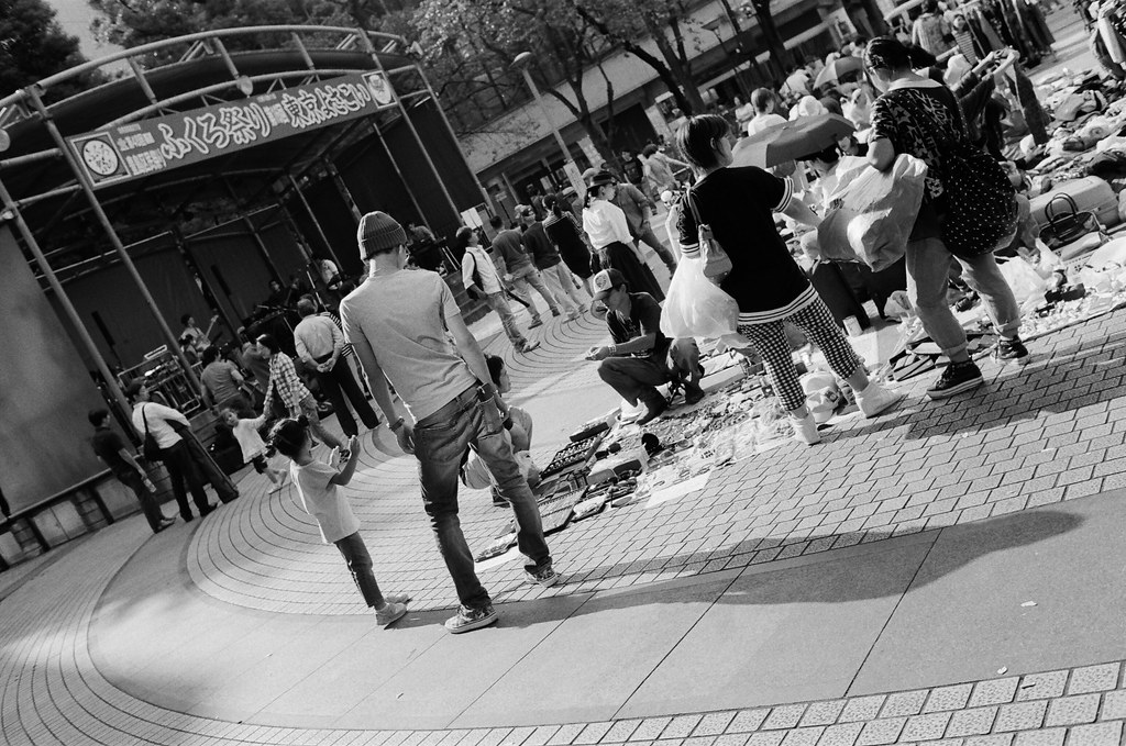 池袋西口公園 東京 Tokyo #DutchAngle 2015/10/04 去了池袋西口公園，那裡有市集，裝了一捲黑白的底片拍，本來以為可以有很多市集的畫面可以拍，但市集很小，一下就逛完了，但在要離開的時候看到一位爸爸站的姿勢很棒！  Nikon FM2 Nikon AI AF Nikkor 35mm F/2D Kodak TRI-X 400 / 400TX 1274-0017 Photo by Toomore