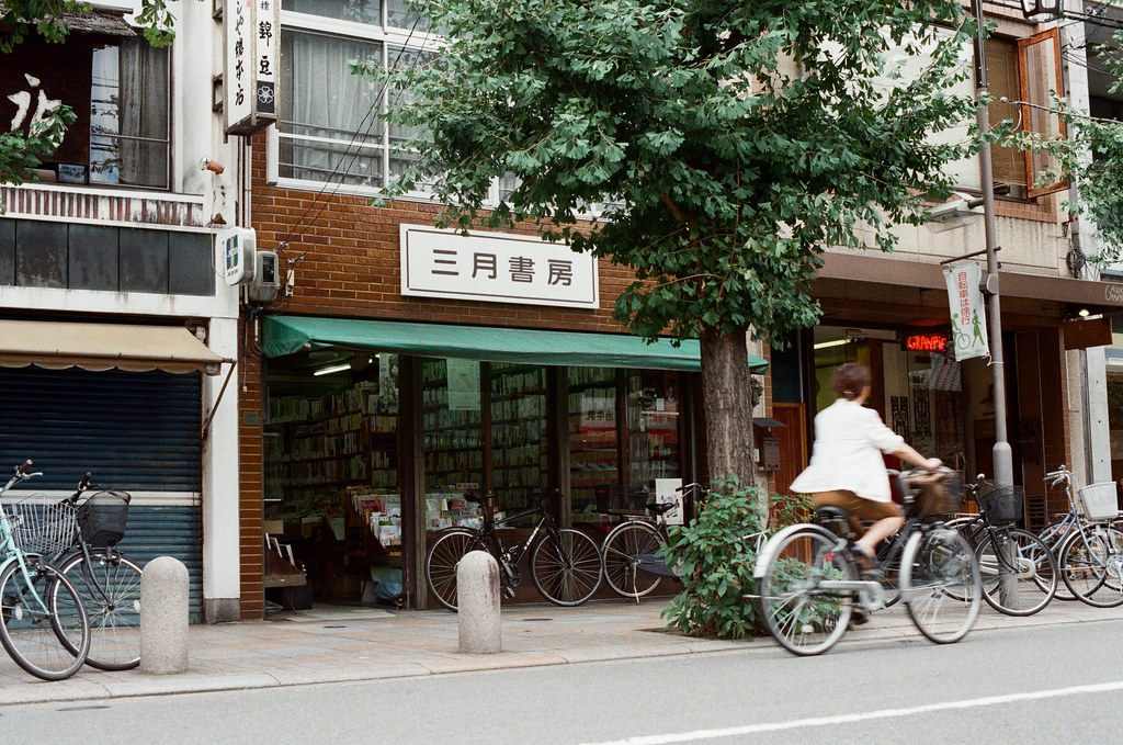 三月書房 寺町通 京都 Kyoto / Kodak ColorPlus / Nikon FM2 2015/09/27 整理照片的時候發現我那時候在寺町通也拍了滿多街上騎腳踏車的路人，這裡街道不寬，兩旁都有看起來好像是歷史很久的店家，店家門面都很有特色。  我想起來了，那時候拍照有規定自己畫面中一定要有當地人入鏡，因為之前拍太多空無一人的畫面，畫面太過空寂。  Nikon FM2 Nikon AI Nikkor 50mm f/1.4S Kodak ColorPlus ISO200 0985-0028 Photo by Toomore