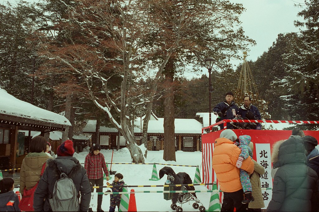 北海道神宮節分祭 Hokkaido, Japan / Fujifilm 500D 8592 / Nikon FM2 2016/02/04 北海道神宮節分祭，有對妖怪丟納豆的儀式，第一次搞懂原來丟納豆的祭典是怎樣的一回事，很新鮮。  那時候天空又飄起雪來，有點冷，站在那裡等很久，附近的居民慢慢聚集在舞台前，等到開始丟祈福的納豆時，大家都往前擠，有點恐怖！  不過真的還滿好玩的，這是這趟旅行第二次來到北海道神宮。  後來回到札幌車站附近的郵便局買明信片，看到電視在轉播各地的節分祭活動，稍微停下來看一下新聞，看看有沒有拍到我！  Nikon FM2 Nikon AI AF Nikkor 35mm F/2D Fujifilm 500D 8592 1114-0010 Photo by Toomore