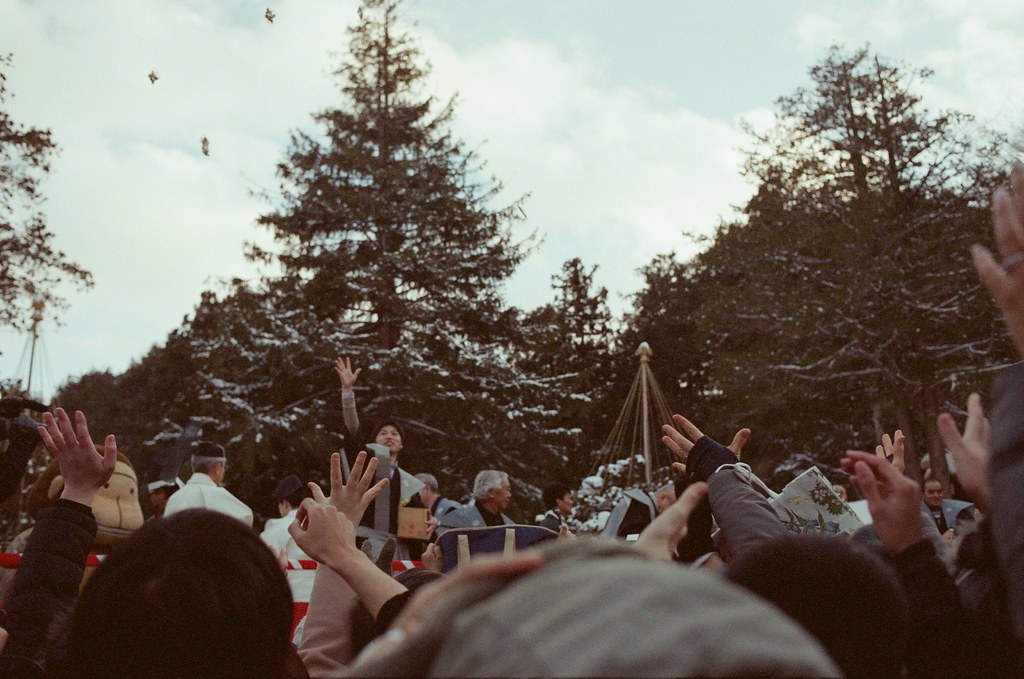 北海道神宮節分祭 Hokkaido, Japan / Fujifilm 500D 8592 / Nikon FM2 2016/02/04 北海道神宮節分祭，有對妖怪丟納豆的儀式，第一次搞懂原來丟納豆的祭典是怎樣的一回事，很新鮮。  那時候天空又飄起雪來，有點冷，站在那裡等很久，附近的居民慢慢聚集在舞台前，等到開始丟祈福的納豆時，大家都往前擠，有點恐怖！  不過真的還滿好玩的，這是這趟旅行第二次來到北海道神宮。  後來回到札幌車站附近的郵便局買明信片，看到電視在轉播各地的節分祭活動，稍微停下來看一下新聞，看看有沒有拍到我！  Nikon FM2 Nikon AI AF Nikkor 35mm F/2D Fujifilm 500D 8592 1114-0022 Photo by Toomore