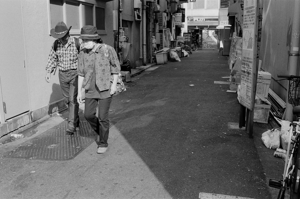 池袋 東京 Tokyo 2015/10/04 從巷口走出來的一對老人。有的時候我都會故意等畫面中的人走的我想要的位置，像是這張，他們從遠方走過來，如果太早按快門，他們就會小小一個，有點可惜，況且他們是一對老夫妻，也很有故事畫面。  Nikon FM2 Nikon AI AF Nikkor 35mm F/2D Kodak TRI-X 400 / 400TX 1274-0024 Photo by Toomore
