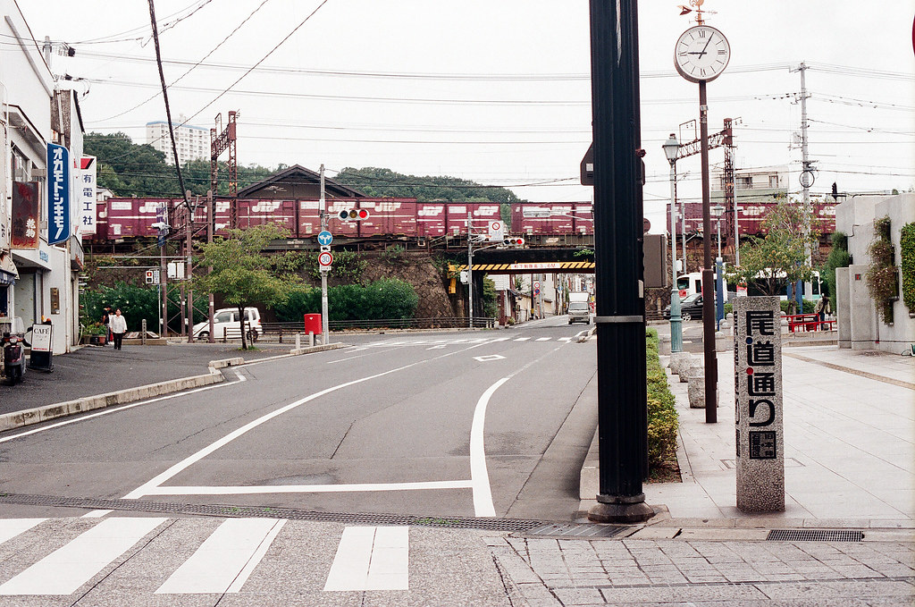尾道 おのみち Onomichi, Hiroshima 2015/08/30 剛好一輛貨運列車經過，和路旁的時間一起入鏡。  Nikon FM2 / 50mm FUJI X-TRA ISO400 Photo by Toomore