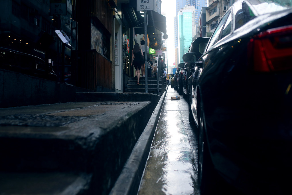 Street Hong Kong / Sigma 35mm / Canon 6D 香港下起雨了，稍微不那麼熱，這樣就可以拍雨天的場景。  這是一個意義不明的對焦，我是對在路面上一個包裹，而不是正在上階梯的女士。  Canon 6D Sigma 35mm F1.4 DG HSM Art IMG_1120 Photo by Toomore
