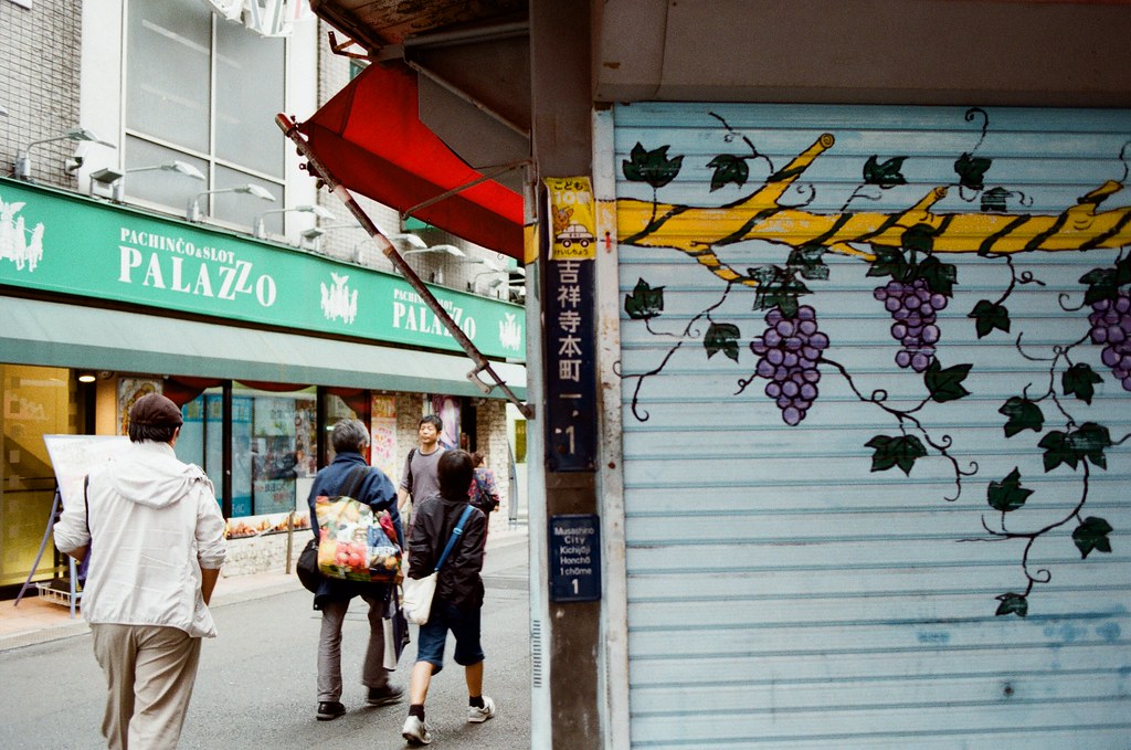 吉祥寺 Tokyo, Japan / Kodak ColorPlus / Nikon FM2 在吉祥寺的巷弄裡鑽來鑽去，好像有點太早去了，有些店家沒有開門，不知道是比較晚開還是真的沒在營業。  我就站在街道的一個位置，構圖調整好後，等待路人走到我要的畫面中，然後按下快門！  這幾天一直很想要寫信給妳，但是一直想不到該怎樣起頭，問候妳好不好又很老套、寫很多我的近況又不確定妳是否想看。  還是學妳用ㄟ當開頭？  Nikon FM2 Nikon AI AF Nikkor 35mm F/2D Kodak ColorPlus ISO200 0995-0008 2015/10/01 Photo by Toomore